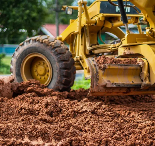 Caterpillar 140M AWD grader preparing a large industrial pad